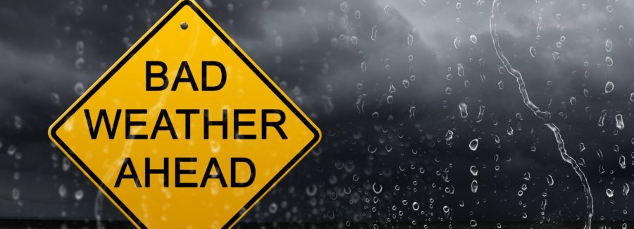 yellow warning sign of bad weather ahead against stormy sky