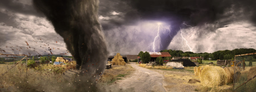 View of a large tornado destroying a barn