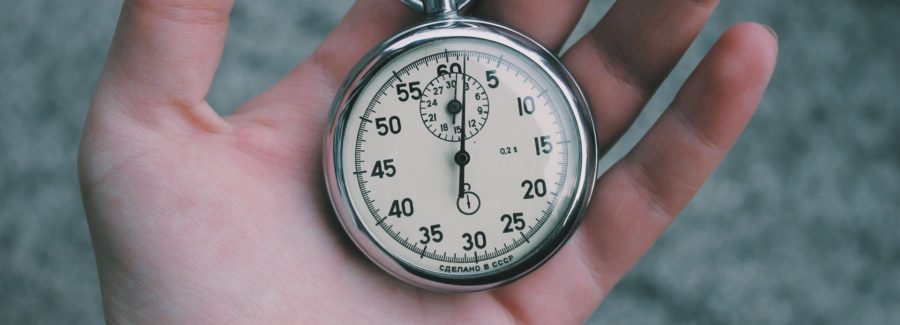 A hand holding a stop watch.
